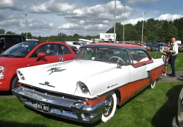 A white and red 1950s two-door with tail fins